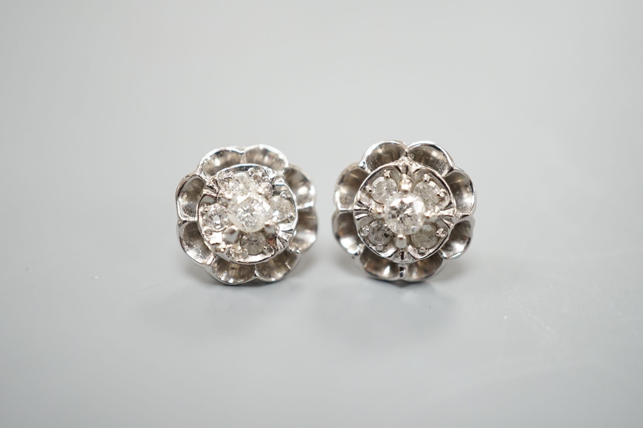 A pair of 750 white metal and five stone diamond cluster set earrings, 10mm, gross weight 3.2 grams.